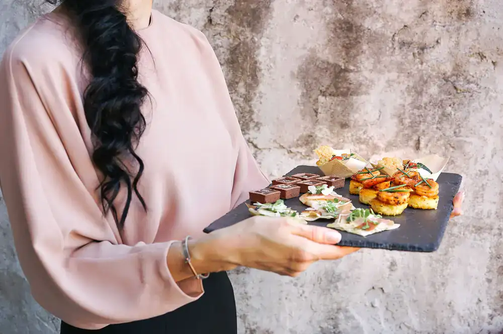 Waiter holding tray of elegant canapes