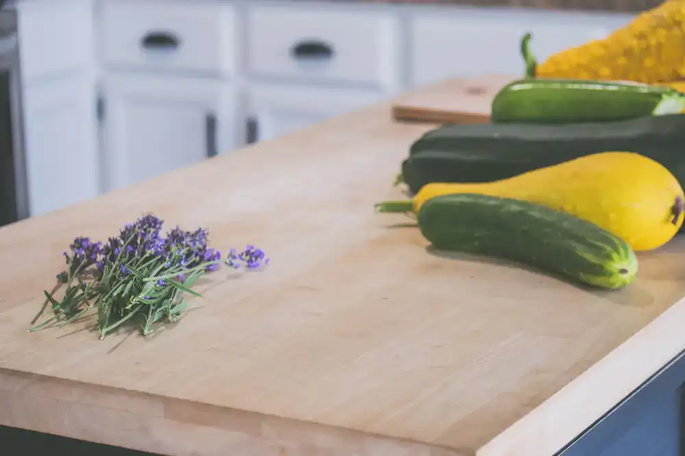 Fresh seasonal vegetables and herbs on a wooden prep table