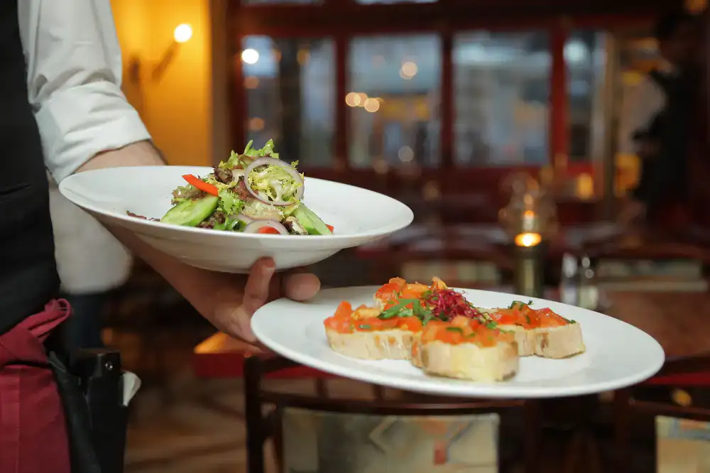 Waitstaff beautifully plating dishes for an event